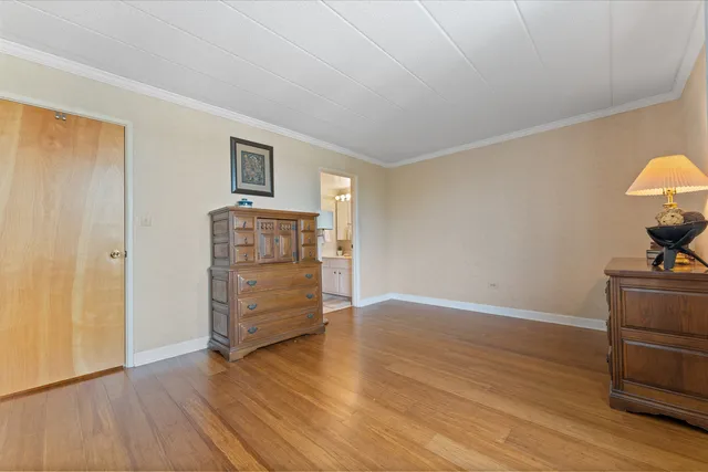 a view of an empty room with wooden floor and cabinet