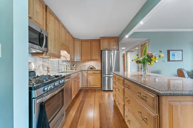 a kitchen with stainless steel appliances granite countertop a sink stove and refrigerator