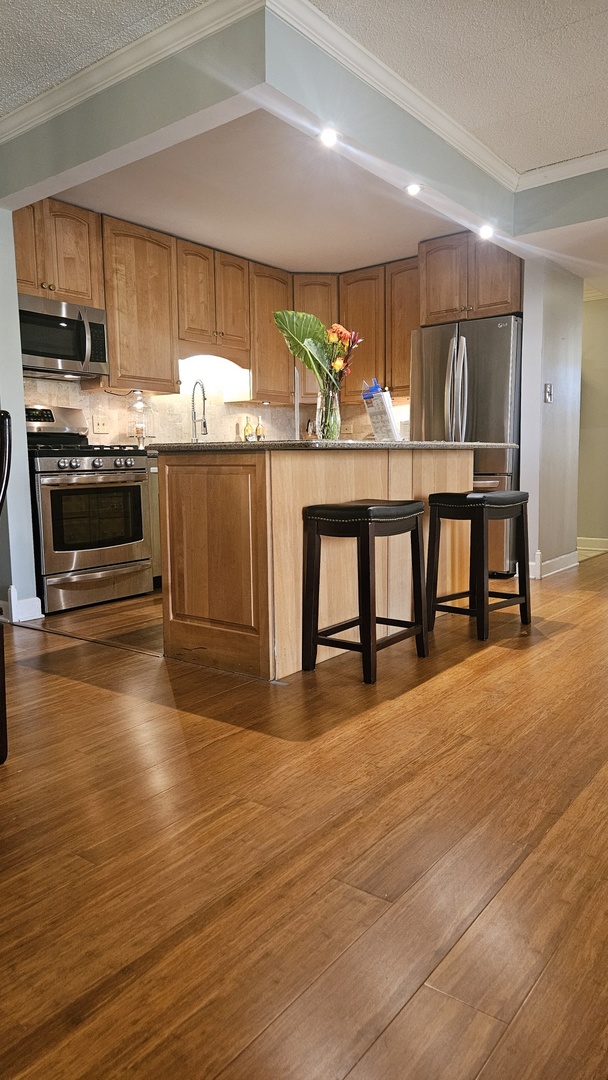110 West Butterfield Road, Unit 502S Elmhurst, IL 60126 - Photo 9 of 31 a kitchen with stainless steel appliances granite countertop a stove a sink and a refrigerator