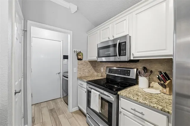 a kitchen with stainless steel appliances granite countertop a stove microwave and refrigerator