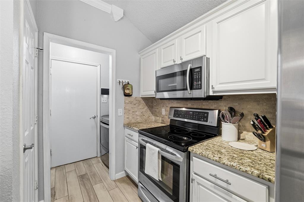 5104 Valley Village Drive Fort Worth, TX 76123 - Photo 11 of 28 a kitchen with stainless steel appliances granite countertop a stove microwave and refrigerator