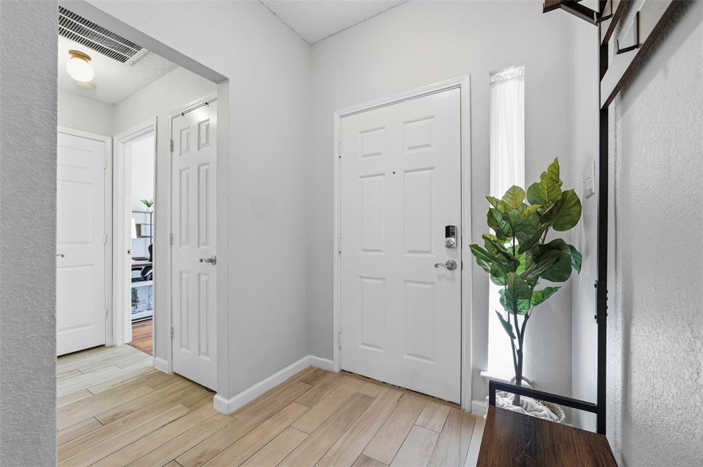 5104 Valley Village Drive Fort Worth, TX 76123 - Photo 13 of 28 a view of a hallway with wooden floor and a potted plant