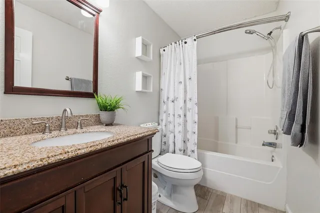 a bathroom with a granite countertop sink toilet and shower