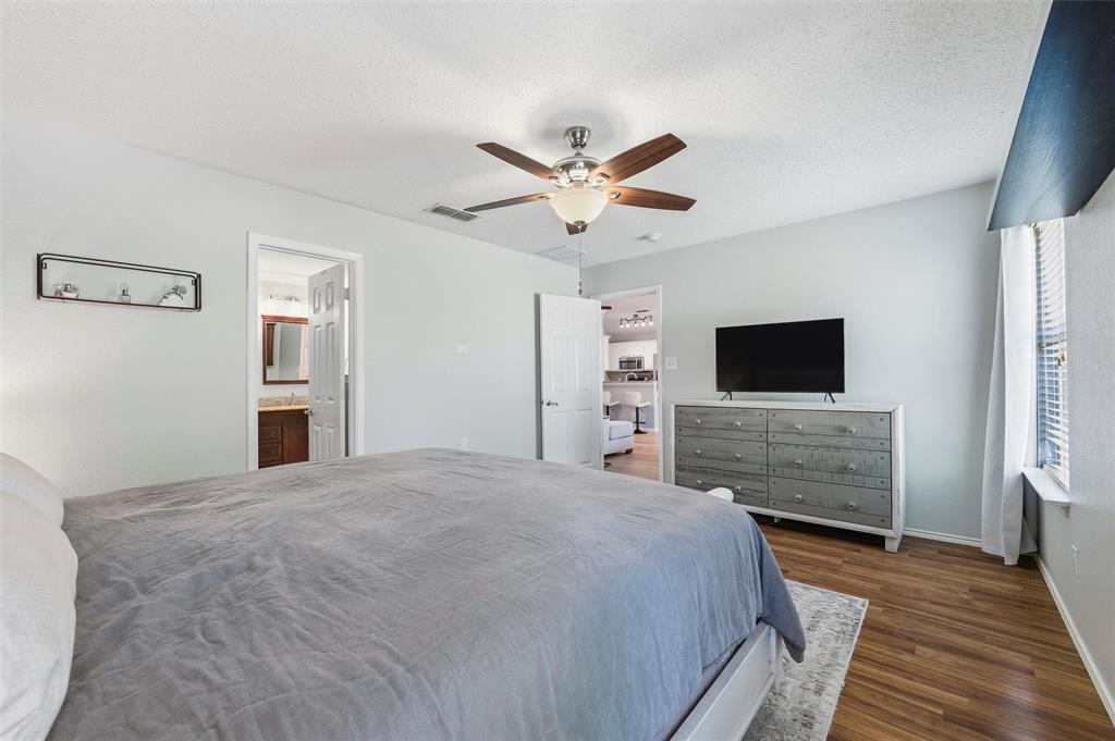 5104 Valley Village Drive Fort Worth, TX 76123 - Photo 19 of 28 a bedroom with a bed and a flat screen tv