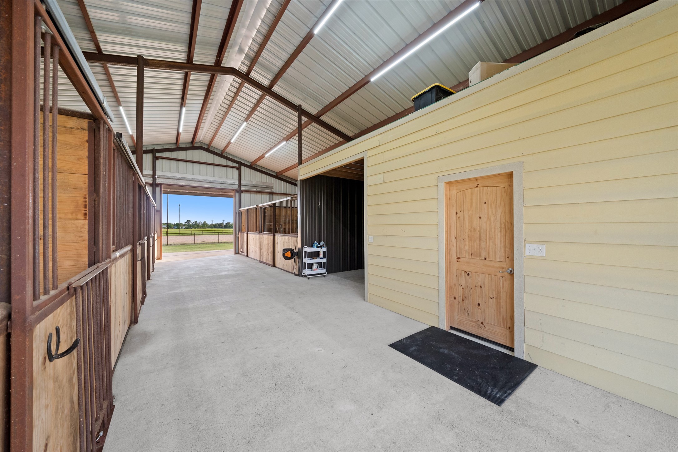 1402 Eagle Ferry Road Anahuac, TX 77514 - Photo 8 of 48 Positioned off the 12’ wide concrete center aisle, this climate-controlled 12’ x 14’ tack room features a mini-split A/C unit, providing quick access from both stalls and arena.