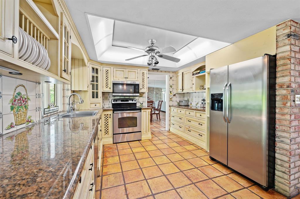 4620 Northeast 25th Avenue Fort Lauderdale, FL 33308 - Photo 13 of 30 a kitchen with stainless steel appliances granite countertop a refrigerator a stove and a sink with cabinets