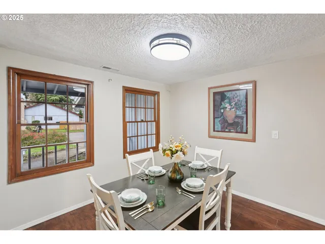 a view of a dining room with furniture a potted plant and wooden floor
