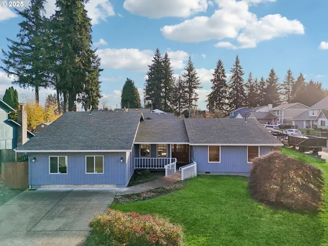 a aerial view of a house next to a big yard and large trees