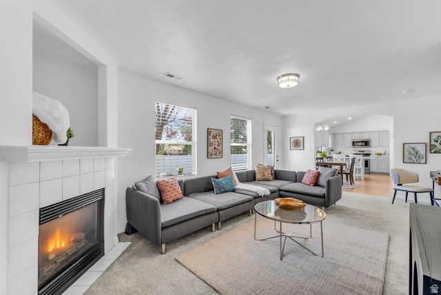 1147 West State Road Lehi, UT 84043 - Photo 11 of 31 Living room with a tiled fireplace, large windows providing natural light, and a recessed display niche