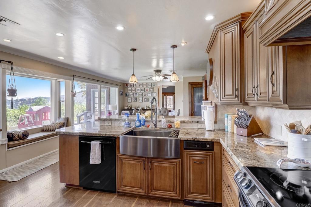 11615 Legendale Drive Lakeside, CA 92040 - Photo 6 of 33 a kitchen with kitchen island granite countertop a sink cabinets and stainless steel appliances