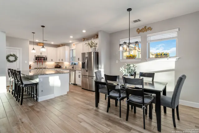 a kitchen with refrigerator a table and chairs