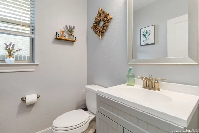 a bathroom with a toilet a sink and mirror