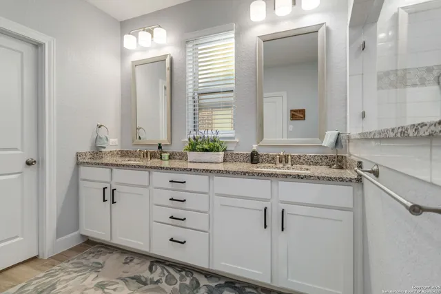 a bathroom with a granite countertop sink and a mirror