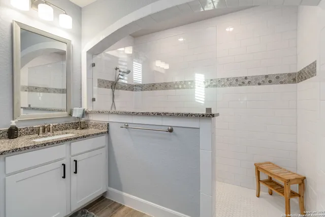 a bathroom with a granite countertop sink and a mirror