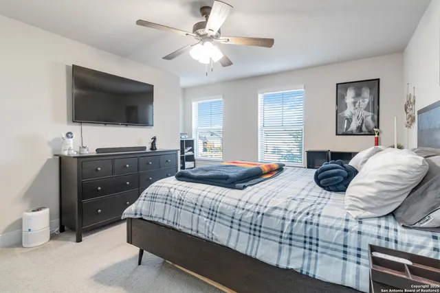 a bedroom with a bed a window and a flat screen television