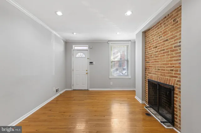 a view of empty room with wooden floor and fireplace