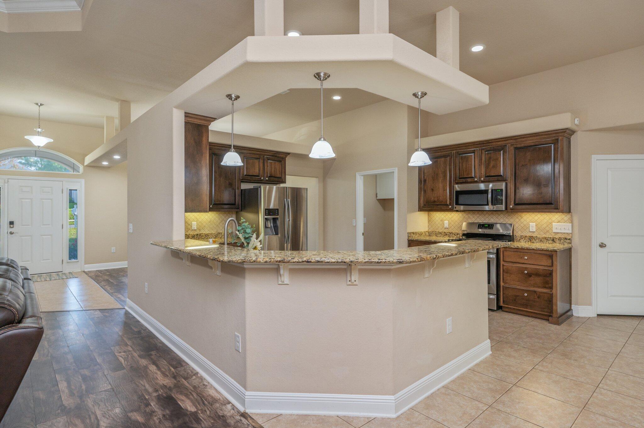 513 Vale Loop Crestview, FL 32536 - Photo 11 of 50 a kitchen with stainless steel appliances granite countertop a sink and cabinets