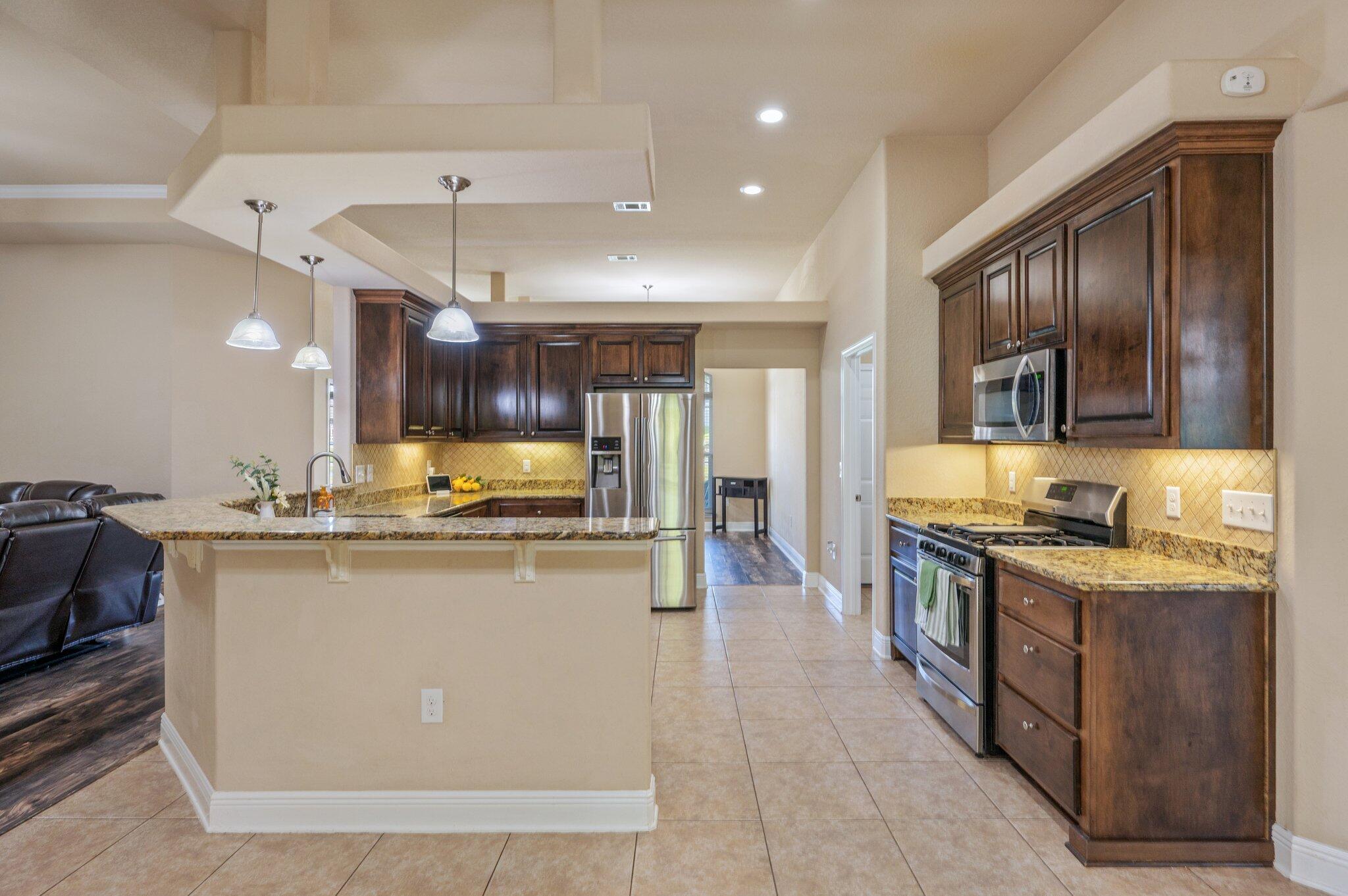 513 Vale Loop Crestview, FL 32536 - Photo 12 of 50 a kitchen with stainless steel appliances granite countertop a stove and a sink