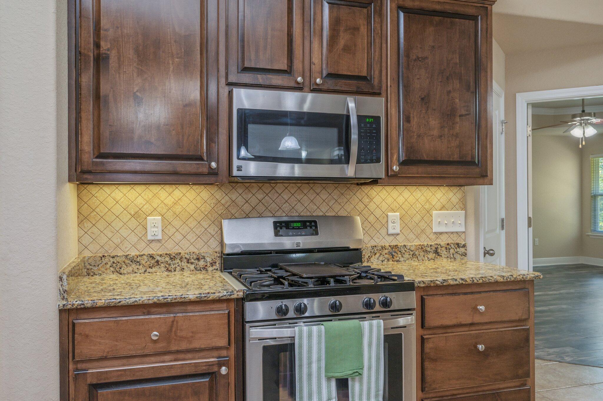 513 Vale Loop Crestview, FL 32536 - Photo 15 of 50 a kitchen with granite countertop cabinets and stove top oven