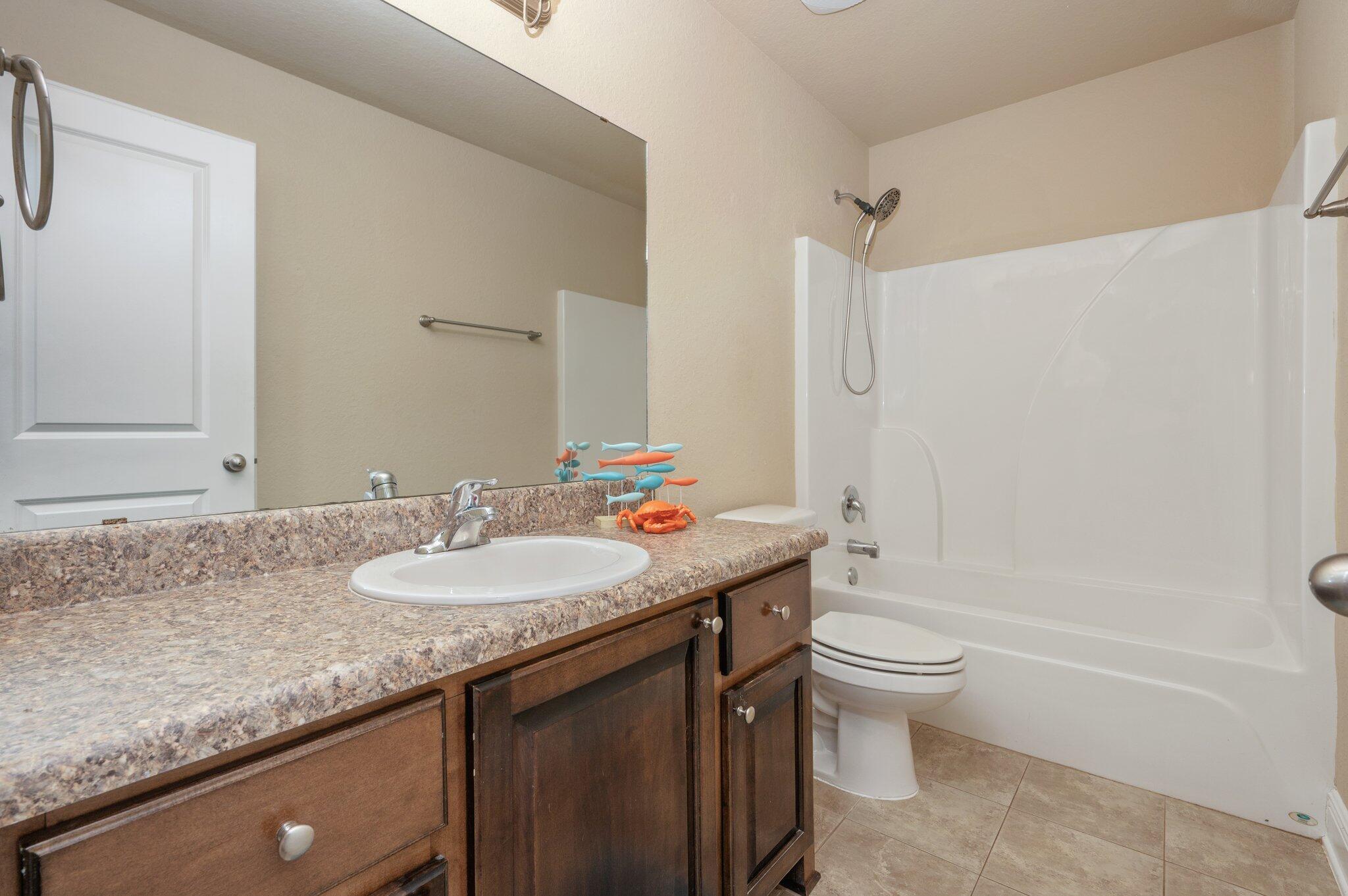 513 Vale Loop Crestview, FL 32536 - Photo 36 of 50 a bathroom with a granite countertop sink a toilet and a bathtub