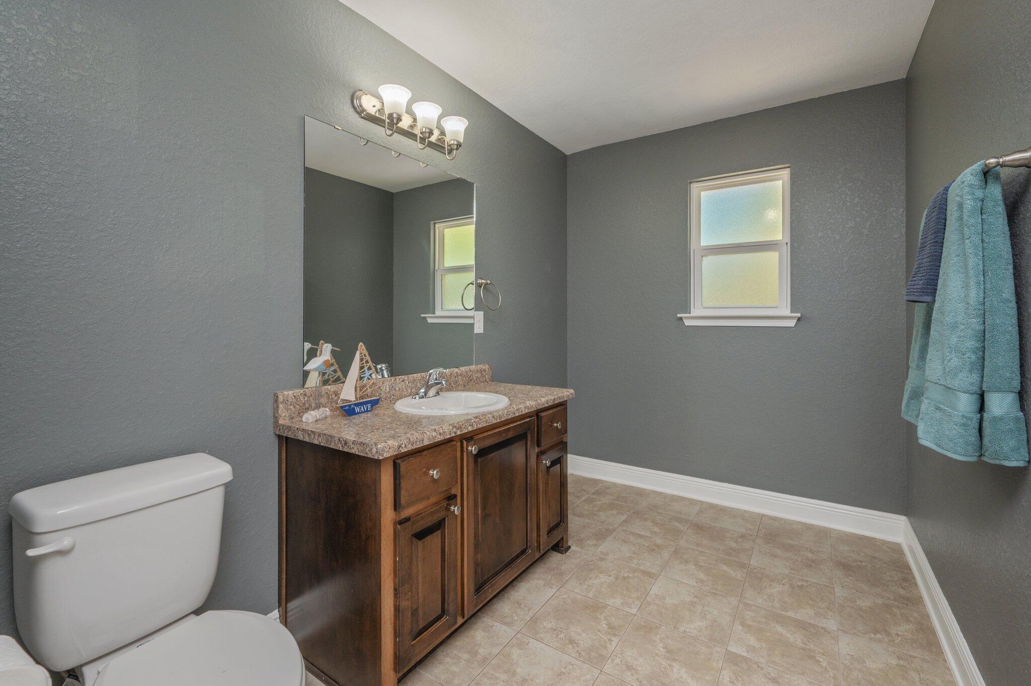 513 Vale Loop Crestview, FL 32536 - Photo 39 of 50 a bathroom with a granite countertop sink a toilet and a mirror