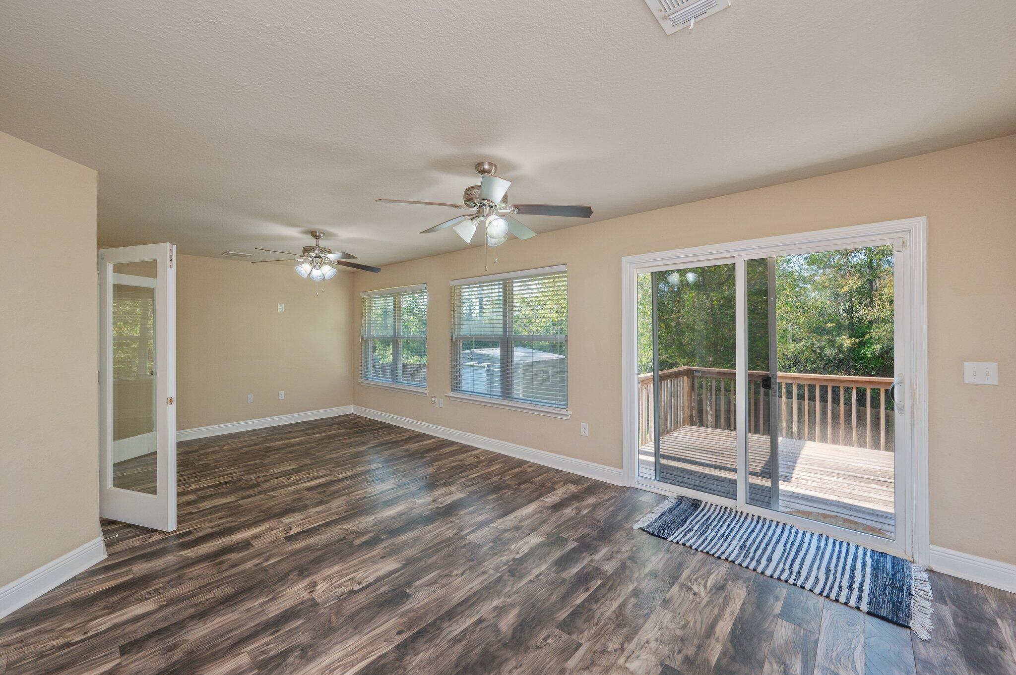 513 Vale Loop Crestview, FL 32536 - Photo 42 of 50 a view of an empty room with wooden floor and a window