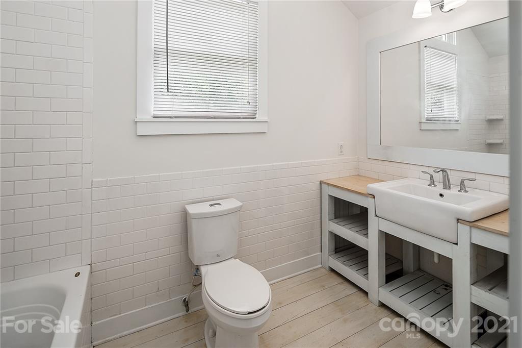 327 Marsh Road Charlotte, NC 28209 - Photo 32 of 48 a bathroom with a toilet a sink a mirror and a window
