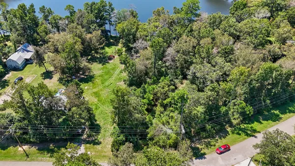 an aerial view of residential house with outdoor space and trees all around