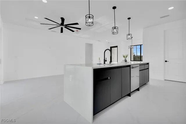 a kitchen with a sink a counter space appliances and cabinets