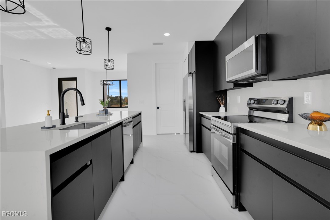 3602 20th Street Southwest Lehigh Acres, FL 33976 - Photo 16 of 40 a kitchen with kitchen island granite countertop a sink stainless steel appliances and cabinets