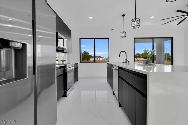 a view of a kitchen with a sink and stainless steel appliances