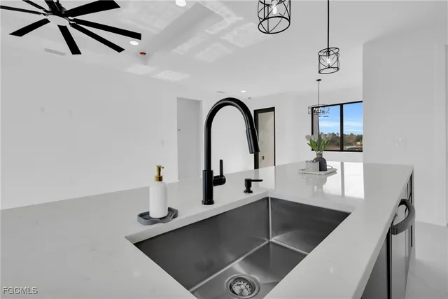 a view of a kitchen with a sink and a ceiling fan