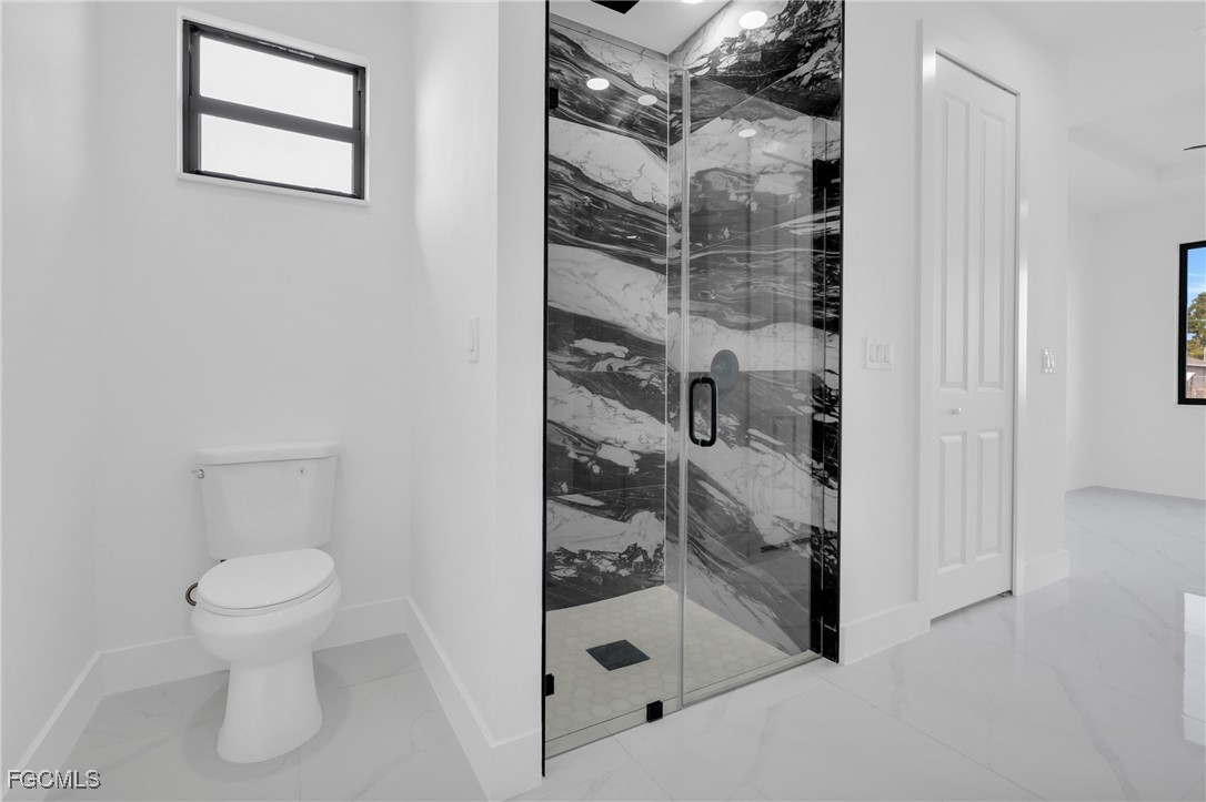 3602 20th Street Southwest Lehigh Acres, FL 33976 - Photo 28 of 40 a bathroom with a glass shower door