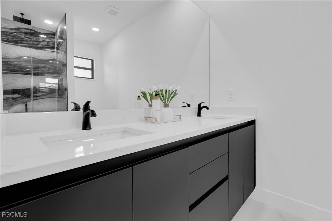 3602 20th Street Southwest Lehigh Acres, FL 33976 - Photo 31 of 40 a bathroom with a sink and a mirror