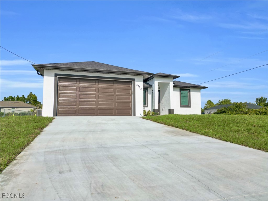 3602 20th Street Southwest Lehigh Acres, FL 33976 - Photo 8 of 40 a front view of a house with a yard and garage