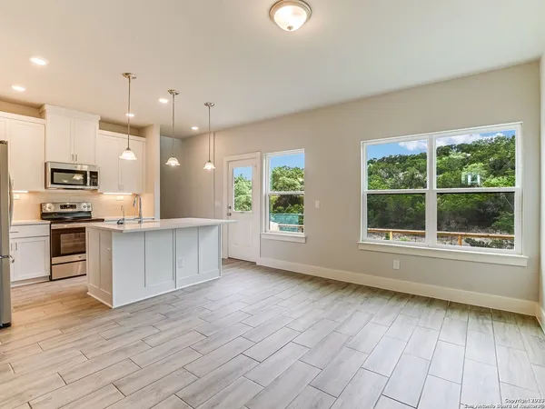 a kitchen with a refrigerator a sink and wooden floor