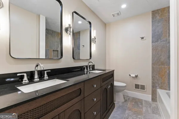 a bathroom with a granite countertop sink and a mirror