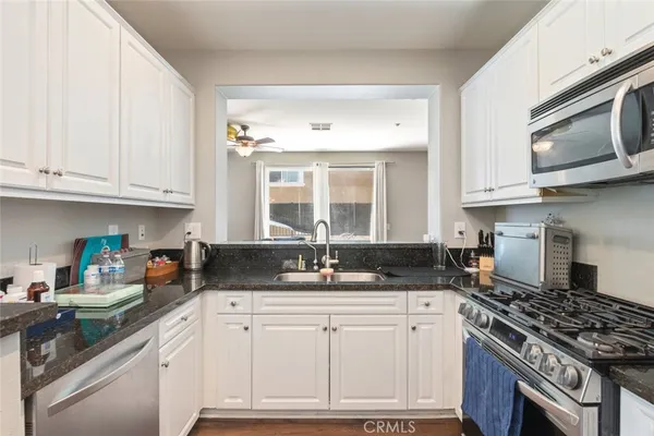 a kitchen with granite countertop a sink stove and cabinets
