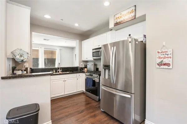 a kitchen with stainless steel appliances a refrigerator and a stove top oven