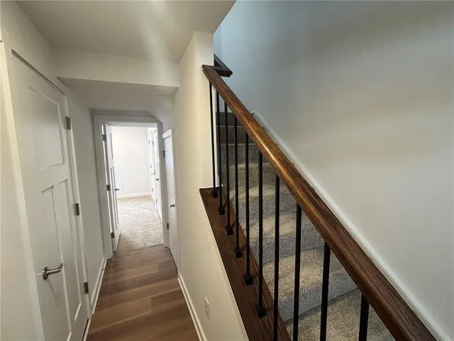 a view of a hallway with wooden floor and stairs