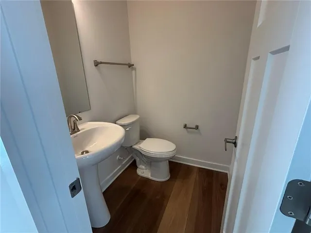 a bathroom with a granite countertop toilet a sink and a mirror