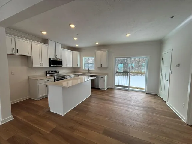 a kitchen with stainless steel appliances granite countertop a stove a sink and a refrigerator