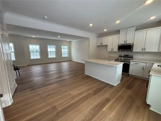a large kitchen with cabinets and wooden floor