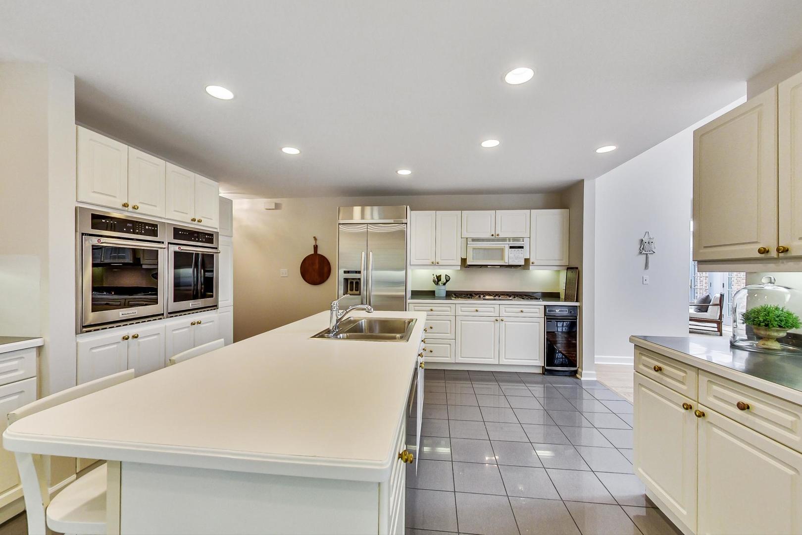 180 Westview Road Winnetka, IL 60093 - Photo 13 of 31 a large white kitchen with a stove top oven a sink dishwasher and cabinets with wooden floor