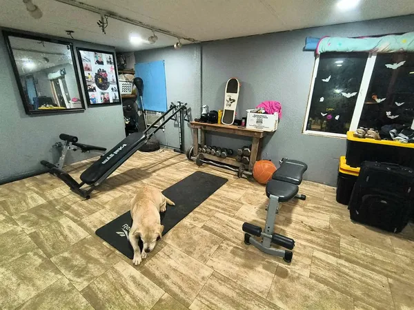a room with gym equipment and a view of living room