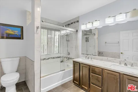 a bathroom with a double vanity sink mirror and toilet