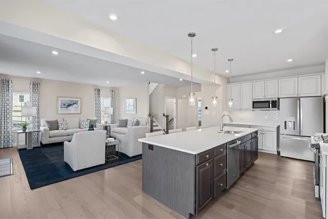 a large white kitchen with a large counter top appliances and cabinets