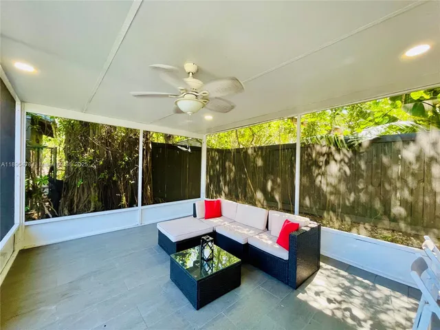 a living room with patio furniture and a floor to ceiling window