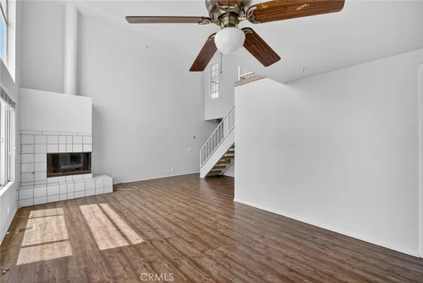 a view of a livingroom with wooden floor and a fireplace