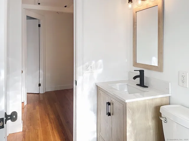 a bathroom with a sink a toilet and a mirror